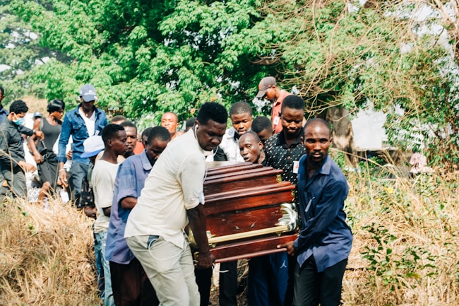 Grupo de personas llevando el atáud de un familiar hacia el cementerio