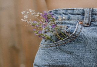 Una mujer con flores en el bolsillo de su pantalón